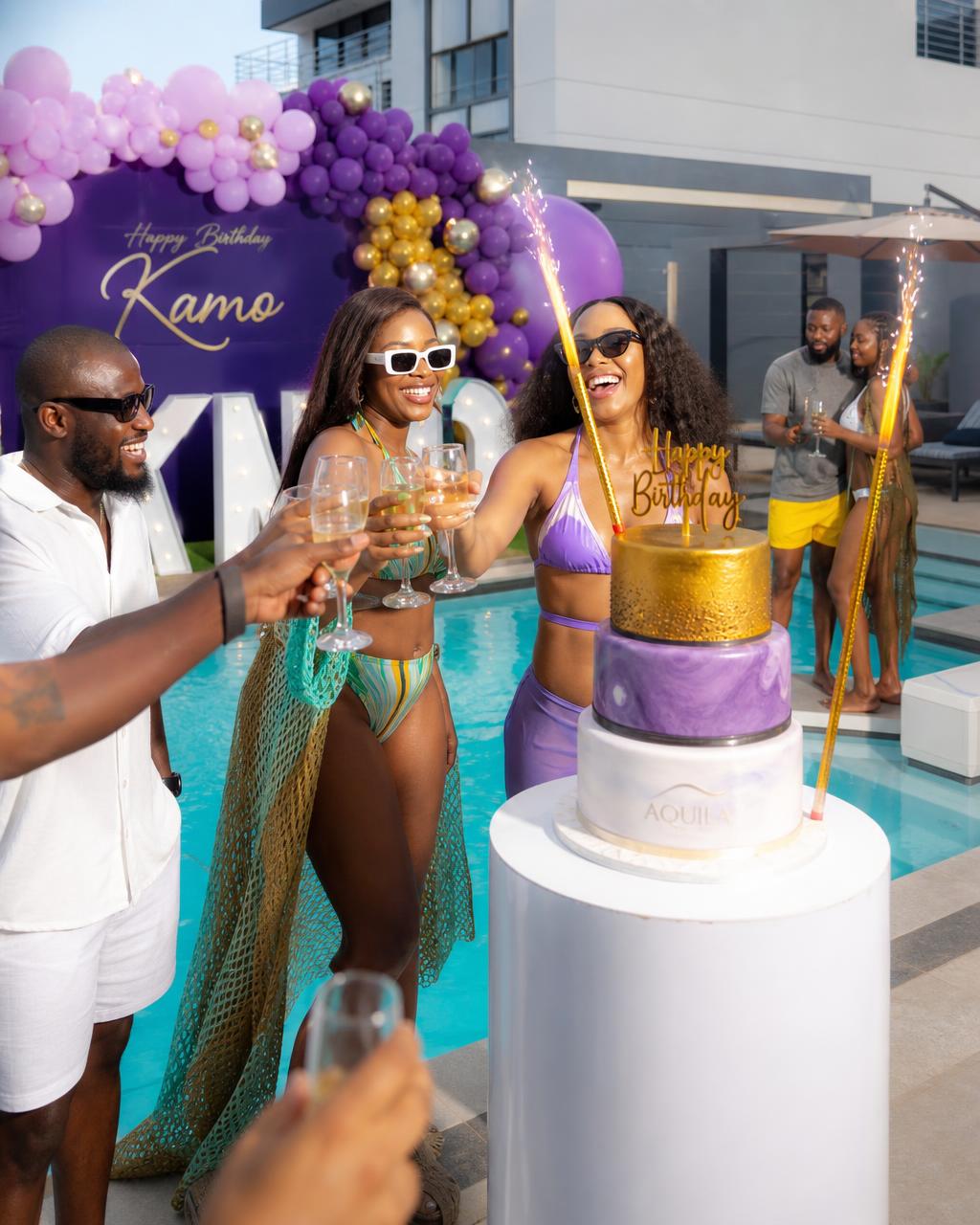 Friends celebrating a birthday around a pool.